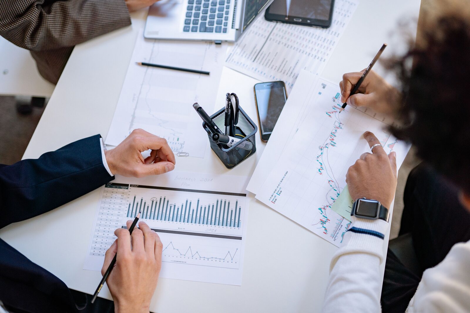 Equipa a analisar dados e documentos de uma empresa, numa mesa de trabalho